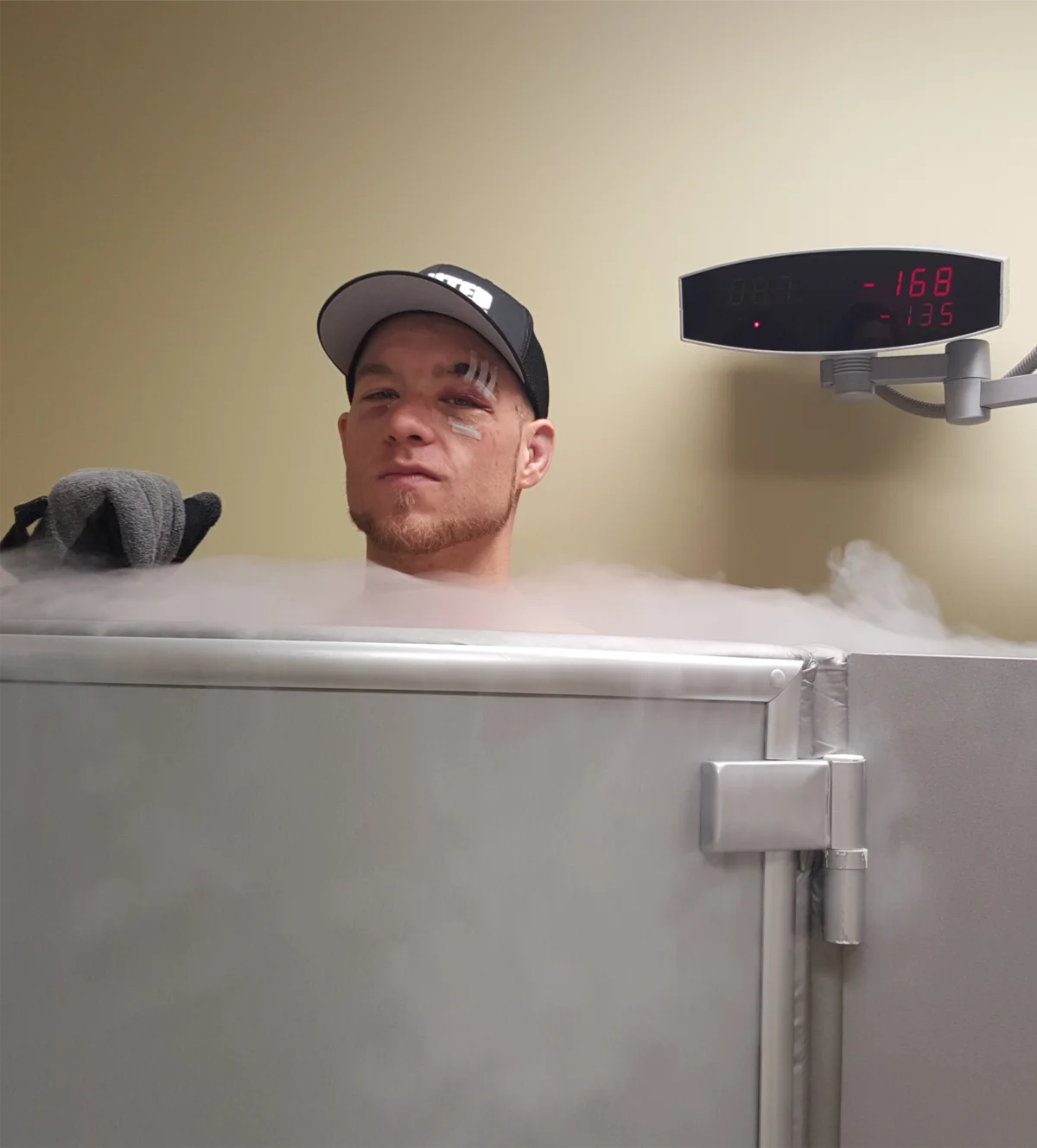 Athlete in cryotherapy chamber with cold vapor mist
